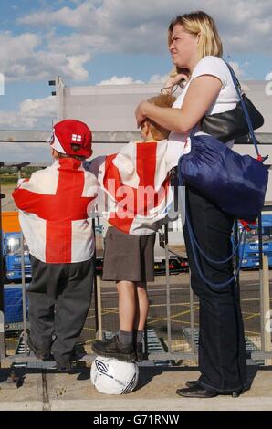 I fan espulsi attendono l'arrivo della squadra inglese all'aeroporto di Luton dopo che la squadra ha perso contro il Portogallo nelle finali del quarto di Euro 2004 della scorsa notte a Lisbona. Foto Stock