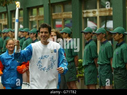 Tim Henman attraversa l'All England Lawn Tennis Club con la torcia olimpica di Wimbledon. Foto Stock