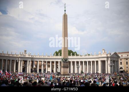 Pellegrini da tutto il mondo arrivano in Piazza San Pietro a Città del Vaticano per vedere la canonizzazione dei Papi Giovanni XXIII e Giovanni Paolo II che domani diventeranno santi. Foto Stock