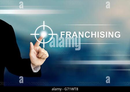 Business mano spingendo il pulsante di franchising su una interfaccia touch-screen Foto Stock