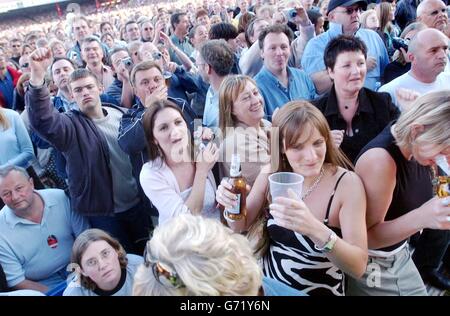 I fan guardano Sir Elton John esibirsi dal vivo sul palco all'Ashton Gate Stadium di Bristol. Foto Stock