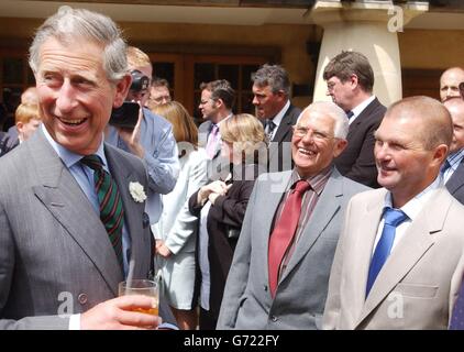 Prince of Wales parla con George James, 76 anni, e suo figlio Robert, 46 anni, da Penzance, Cornovaglia, nella sua tenuta di Highgrove, durante un ricevimento, per rendere omaggio al personale che ha presidiato gli uffici postali Royal Mail Travelling, sciolti, lunedì 21 giugno 2004. Più di 120 lavoratori che rappresentavano ciascuna delle rotte ferroviarie del paese incontravano il principe nella sua casa vicino a Tetbury, Gloucestershire. Foto Stock