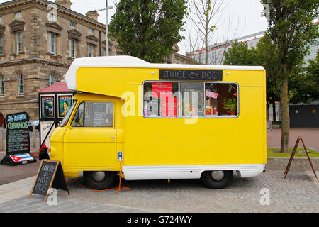 Alimento giallo carrello di succo naturale di frutta e cibo vegetariano parcheggiato in strada Foto Stock