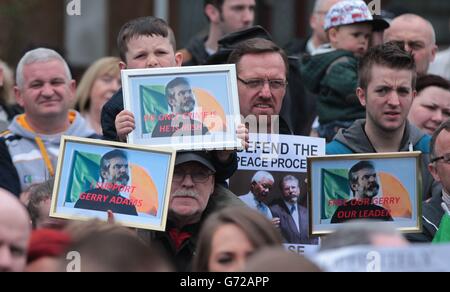 I sostenitori di Sinn Fein, che chiedono il rilascio di Gerry Adams, partecipano ad un'inaugurazione di un murale di lui in The Falls Road, Belfast, Come il vice primo ministro Martin McGuinness ha ribadito la sua convinzione che l'arresto di Adams è politicamente motivato e accusato i membri del servizio di polizia dell'Irlanda del Nord di essere contro il processo di pace. Foto Stock