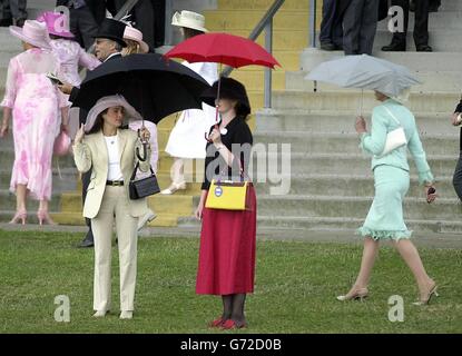 Signore che frequentano Royal Ascot rifugio dalla pioggia che è arrivato l'ultimo giorno della gara. Foto Stock