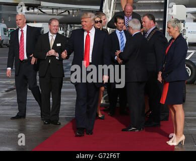 IL magnate STATUNITENSE Donald Trump (centro) arriva all'aeroporto di Shannon in Irlanda per visitare il campo di Doonbeg dopo aver ottenuto il via d'uscita dai capi del consiglio per costellare il famoso quattordicesimo verde sul campo, A seguito di un accordo per svolgere il lavoro su un sistema di dune protette che corre accanto al suo resort di lusso golf nella parte occidentale dell'Irlanda. Foto Stock