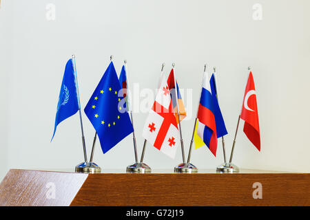 Miniatura bandiere di paesi europei e la bandiera dell'Unione europea sui pennoni su un tavolo di legno. Foto Stock