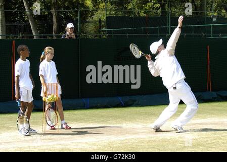 John McEnroe dà una master class ai vincitori del concorso Ariel Ace Tennis Marshall Osei Tutu 12 da Hainault in Essex e Samantha Kenshole 11 da Exeter sui campi di pratica presso l'All England Lawn Tennis Club di Wimbledon, Londra. Foto Stock