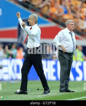 Il manager Arsenal Arsene Wenger (a sinistra) festeggia al fischio finale Come il manager di Hull City Steve Bruce guarda sopra Foto Stock