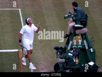 Mark Philippoussis dall'Australia contesta una chiamata di linea con l'umpire Eric Molina durante il terzo set della sua partita contro Tim Henman della Gran Bretagna ai Campionati di tennis del prato a Wimbledon. Il sig. Molina ha lanciato a Philippossis un monito per giurare. , NESSUN UTILIZZO DEL TELEFONO CELLULARE. Foto Stock