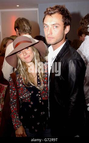 Jude Law con la sua fidanzata Sienna Miller arriva per la proiezione celebrità dell'ultimo documentario di Michael Moore Fahrenheit 9/11, tenuto presso il Vue Cinema, Leicester Square, nel centro di Londra. Foto Stock