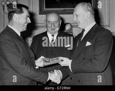 Il campione del mondo di corse automobilistiche Jack Brabham (l) riceve dal Marchess Camden, presidente del Royal Automobile Club Competitions Competitions Committee (r), una medaglia d'oro per il suo unico risultato nella vittoria dei campionati del conducente e del costruttore nello stesso anno. Nel centro si trova Howard Mathias, vicepresidente senior del RAC, che ha presieduto una cena presso la sede centrale del Pall Mall del club al momento della presentazione. Foto Stock