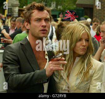 L'attore Jude Law e la sua fidanzata Sienna Miller arrivano ai Campionati di tennis di prato per assistere all'incontro di Tim Henman con Mario Ancic dalla Croazia nel quarto finale dei Men's Singles a Wimbledon, Londra. SOLO PER USO EDITORIALE, SENZA USO DI TELEFONO CELLULARE. Foto Stock