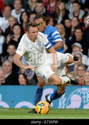 Jonathan Wilkes, in Inghilterra, è scottato dal resto del mondo Edgar Davids, durante la partita di beneficenza Soccer Aid a Old Trafford, Manchester. Foto Stock