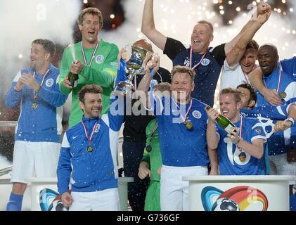 Michael Sheen e Gordon Ramsay del resto del mondo alzano il trofeo dopo aver battuto l'Inghilterra, durante la partita di beneficenza Soccer Aid a Old Trafford, Manchester. Foto Stock