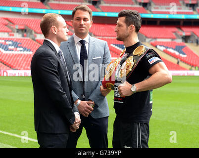 Carl Froch (a destra) e George Grove (a sinistra) vanno testa a testa con Boxing Promotor Eddie Hearn durante una conferenza stampa al Wembley Stadium di Londra. Foto Stock