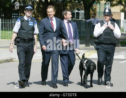 Il primo ministro britannico Tony Blair (2° a sinistra) e il segretario all'interno David Blunkett (centro), affiancati dall'ufficiale di supporto della polizia comunitaria Ton Vincent (a sinistra) e PC Wayne Anstee, quando arrivano al centro della comunità di Somersstown a nord di Londra. Foto Stock