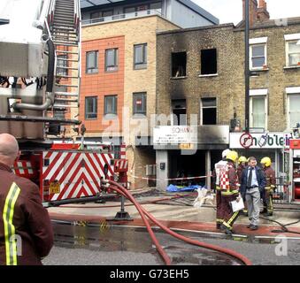 La scena a Bethnal Green, a est di Londra, dove due vigili del fuoco morirono combattendo una briciola in un edificio a tre piani. Si comprende che la coppia era all'ultimo piano dell'edificio, che aveva un negozio al piano terra e appartamenti sopra, quando sembrava che il pavimento sotto di loro cedesse il passo. Furono gravemente feriti e si precipitarono in ospedale, dove entrambi morirono. Foto Stock