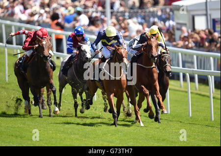 Thistle Bird (centro con cappello giallo) guidato da James Doyle vince la posta in gioco della principessa Elizabeth durante la Giornata delle Signore di Investec all'Ippodromo di Epsom Downs, Surrey. Foto Stock