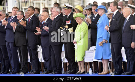 La regina Elisabetta II guarda una performance che mostra il processo del D-Day fino al pezzo post-bellico su Sword Beach durante il commemorazione del 70° anniversario degli sbarchi in Normandia, Ouistreham, Francia. Foto Stock