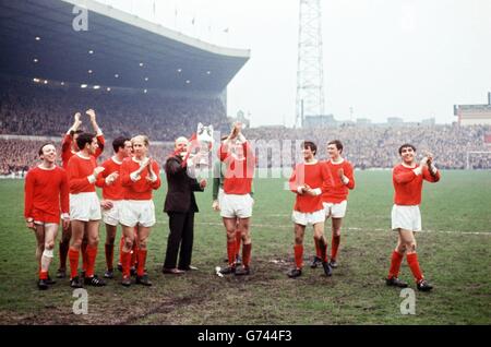 Il manager Manchester United Matt Busby (sesto l) tiene il trofeo League Championship Aloft mentre lui e i suoi giocatori lo sfilano intorno a Old Trafford: (l-r) Nobby Stiles, David Sadler (armi sollevate), Shay Brennan, John Aston, Denis Law (nascosto), Bobby Charlton, Busby, Alex Stepney, Pat Crerand, George Best, Jimmy Ryan, Tony Dunne Foto Stock