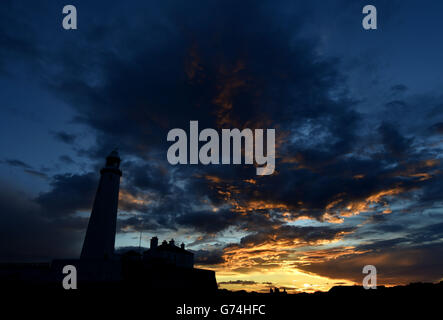 Il sole tramonta dietro il faro di St Mary vicino a Whitley Bay, North Tyneside, mentre il caldo clima continua in tutto il Regno Unito. Foto Stock