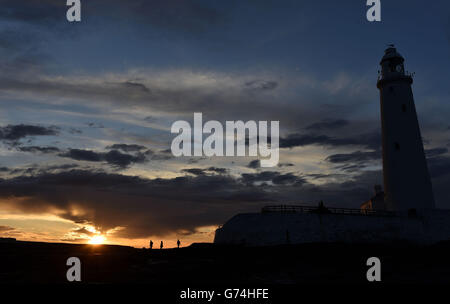 Il sole tramonta dietro il faro di St Mary vicino a Whitley Bay, North Tyneside, mentre il caldo clima continua in tutto il Regno Unito. Foto Stock