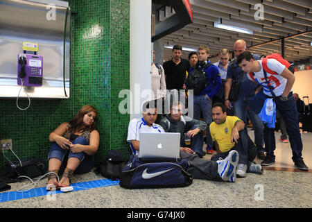 I fan si riuniscono attorno a un computer iMac per guardare Messico v Camerun all'aeroporto internazionale di San Paolo Foto Stock