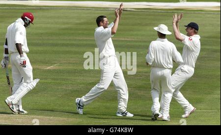 Il bowler inglese Steve Harmison (2° a sinistra) festeggia la presa del wicket del battitore Pedro Collins delle Indie Occidentali (a sinistra) con Michael Vaughan e Andrew Flintoff (a destra), durante il terzo giorno della seconda partita di test della Npower a Edgbaston, Birmingham, sabato 31 luglio 2004. Foto Stock