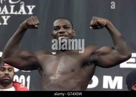 Il campione mondiale di pesi massimi Hasim Rahman, si erge su una bilancia con uno schermo di vetro tra se stesso e il britannico Lennox Lewis mentre pesano per il rematch del titolo World Heavyweight al Mandalay Bay Hotel, Las Vegas. Foto Stock