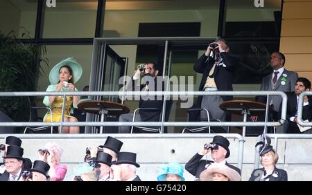 I corridori osservano l'azione dal balcone usando il loro binocolo durante il giorno due del raduno reale di Ascot 2014 all'ippodromo di Ascot, Berkshire. Foto Stock