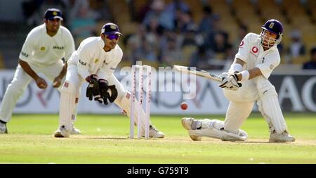 Inghilterra il battitore Mark Butcher (a destra) spazza la palla per quattro corse durante il quarto giorno del secondo test contro l'India allo stadio Sardar Patel di Motera, Ahmedabad, India. Foto Stock