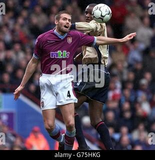 Patrick Vieira di Arsenal (a destra) vince una testata con Olof Mellberg, difensore di Aston Vill, durante la sua partita di premiership fa Barclaycard al Villa Park di Birmingham. Foto Stock