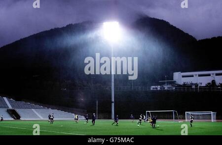 La squadra di calcio scozzese si allea sotto i riflettori sotto la pioggia battente su un campo di allenamento di fronte allo stadio Busan, prima della partita di domani contro la Corea del Sud. Foto Stock