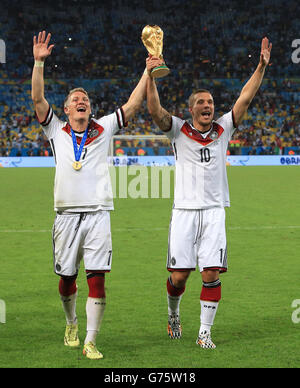 Il Bastian Schweinsteiger della Germania (a sinistra) e Lukas Podolski festeggiano sul Piazzati con il Trofeo FIFA World Cup 2014 Foto Stock