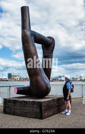 London Greenwich, arte pubblica. Senior l'uomo guarda Gary Hume scultura in bronzo, "libertà Grip' Foto Stock