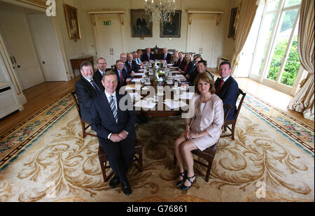 Taoiseach Enda Kenny (davanti a sinistra) e Tanaiste Joan Burton (a destra) con il nuovo gabinetto ad Aras An Uachtarain, Dublino dopo l'odierna rimpasto del gabinetto, come il governo di coalizione fine gael-laburista ha promesso di far pagare il lavoro come una nuova linea di gabinetto è stato annunciato. Foto Stock