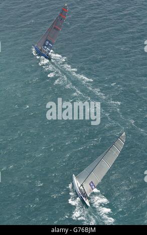 Il team della Great Britain's America's Cup GBR Challenge a bordo di Wight Lightning (in basso) sono lasciati in coda sulla scia dello yacht americano oneworld USA-67 sulla prima gamba a vento durante la loro corsa nel Golfo di Hauraki al largo di Auckland, Nuova Zelanda. La squadra GBR ha subito un turno di penalità di 360 gradi dopo aver colpito USA-67 alla partenza e alla fine ha finito tre minuti 22 secondi dopo i loro avversari. Foto Stock