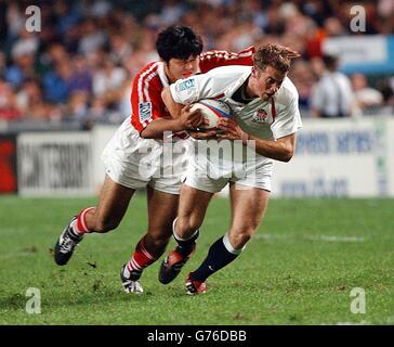 L'inglese James Simpson-Daniel (a destra) lascia la difesa giapponese flatfooted durante la sua vittoria della squadra 47-0 nel primo round del 'Sevens' di Hong Kong. Foto Stock