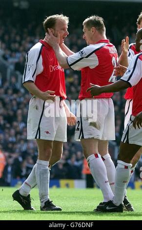 Il Dennis Bergkamp di Arsenal (a sinistra) è abbracciato da Oleg Luzhny (a destra) dopo che Sol Campbell ha segnato il terzo gol contro Newcastle United durante la sesta partita di replay della fa Cup allo stadio Highbury di Arsenal a Londra. Punteggio finale Arsenal 3 Newcastle 0. Foto Stock