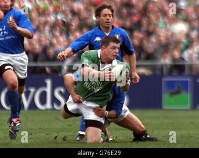 Brian o'Driscoll (C), irlandese, tenta di scaricare sotto pressione i Gert Peens italiani durante la partita dei Lloyds TSB sei nazioni a Lansdowne Road, Dublino. L'Irlanda ha vinto il gioco 32-17. Foto Stock