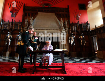 La regina Elisabetta II firma il libro degli ospiti presso la Great Hall del Castello di Edimburgo dopo aver partecipato a un servizio commemorativo per il memoriale di guerra nazionale scozzese presso il Castello di Edimburgo. Foto Stock