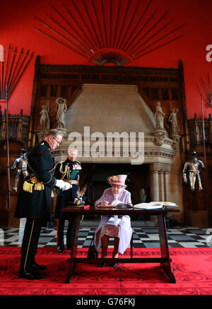 La regina Elisabetta II firma il libro degli ospiti presso la Great Hall del Castello di Edimburgo dopo aver partecipato a un servizio commemorativo per il memoriale di guerra nazionale scozzese presso il Castello di Edimburgo. Foto Stock