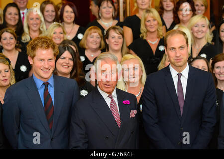 (Sinistra - destra) il principe Harry, il principe del Galles e il duca di Cambridge posano per una foto con i membri del coro delle mogli militari al Business in the Community (BITC) 2014 responsabile Business Awards cena di gala al Royal Albert Hall, Londra. Foto Stock