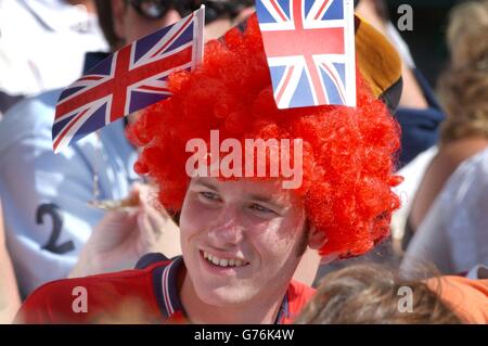 , NESSUN USO COMMERCIALE. Un patriottico tifoso di tennis guarda la star del tennis numero uno degli uomini della Gran Bretagna, Tim Henman, in azione contro Scott Draper dell'Australia sul campo di Wimbledon. Foto Stock