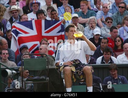 , NESSUN USO COMMERCIALE. I fan della star britannica Tim Henman del tennis numero uno degli uomini hanno fatto onda di una bandiera Union Jack durante la sua partita contro Scott Draper dell'Australia sulla corte centrale di Wimbledon. Foto Stock