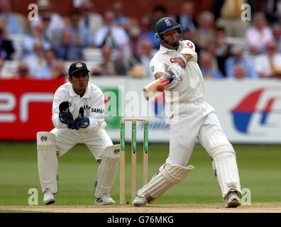 Ajay Ratra (a sinistra), il calciatore indiano, guarda mentre il capitano inglese Nasser Hussain colpisce Anil Kumble per quattro corse durante il primo giorno del primo test match contro l'India a Lord's, Londra. Foto Stock