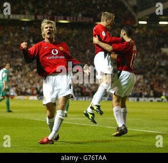 David Beckham di Manchester United festeggia dopo che il compagno di squadra Ryan Giggs (all'estrema destra con Phil Neville) ha aperto il punteggio, durante la loro partita del gruppo F della UEFA Champion League tra Manchester United e Maccabi Haifa a Old Trafford. Foto Stock