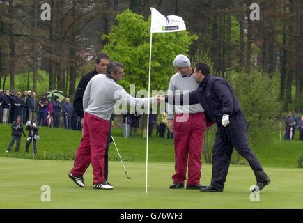 Il capitano del Continental Europe Team Seve Ballesteros (all'estrema sinistra) guarda come il suo compagno di squadra Jose maria Olazabal (all'estrema destra) scuote le mani con l'Irlanda e Paul McGinley della Gran Bretagna, con Padraig Harrington (seconda a destra), dopo che lui (Ballesteros) ha scavato un incredibile colpo di bunker. *... a birdie il 17 e prendere le quattro palle mattutine nel Seve Trophy 2002, a Druids Glen in Co. Wicklow, Irlanda. Foto Stock