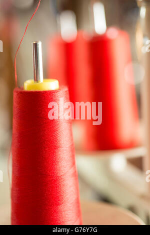 Bobina di filo rosso su una macchina da cucire il pin Foto Stock